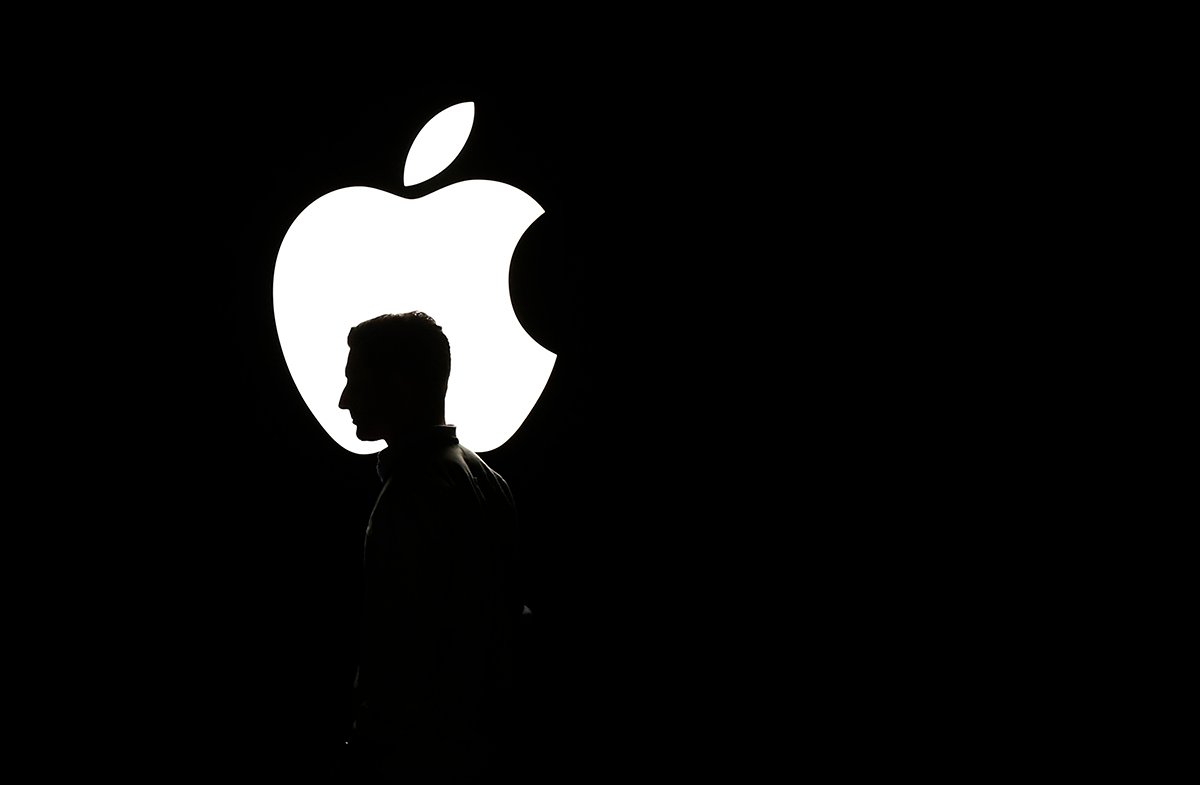 Мужчина проходит перед логотипом Apple во время презентации продукта в концертном зале Bill Graham Civic Auditorium в Сан-Франциско, Калифорния, США, 9 сентября 2015. Фото: Mobica Davey / EPA