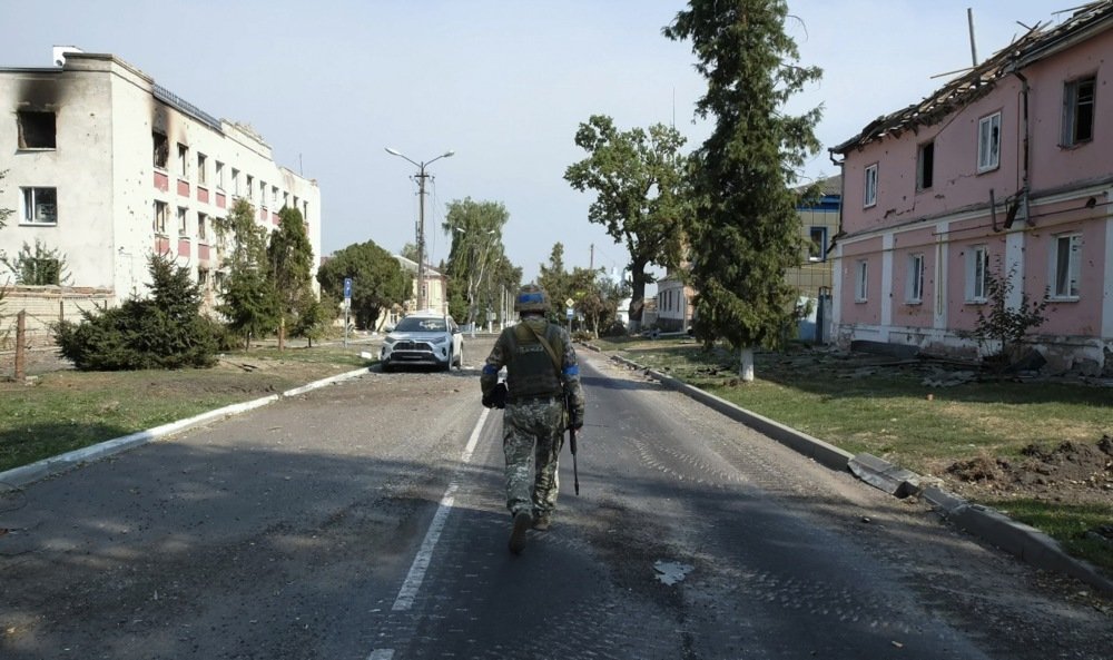 Украинский военнослужащий идет возле поврежденных зданий в центре города Суджа, Курская область. Фото: Stringer / EPA-EFE