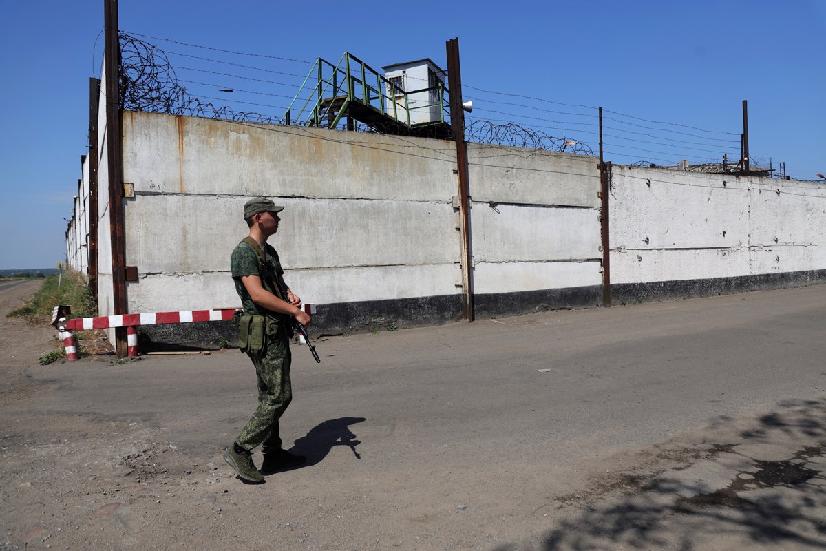 Российский военный патрулирует тюрьму в Оленовке, 29 июля 2022 года. Фото: AP Photo / Scanpix / LETA