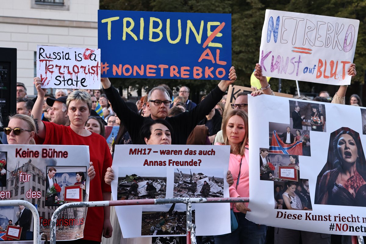 Протестующие держат плакаты во время акции против выступления Анны Нетребко на сцене Берлинской государственной оперы в Берлине, Германия, 15 сентября 2023 года. Фото: Clemens Bilan / EPA