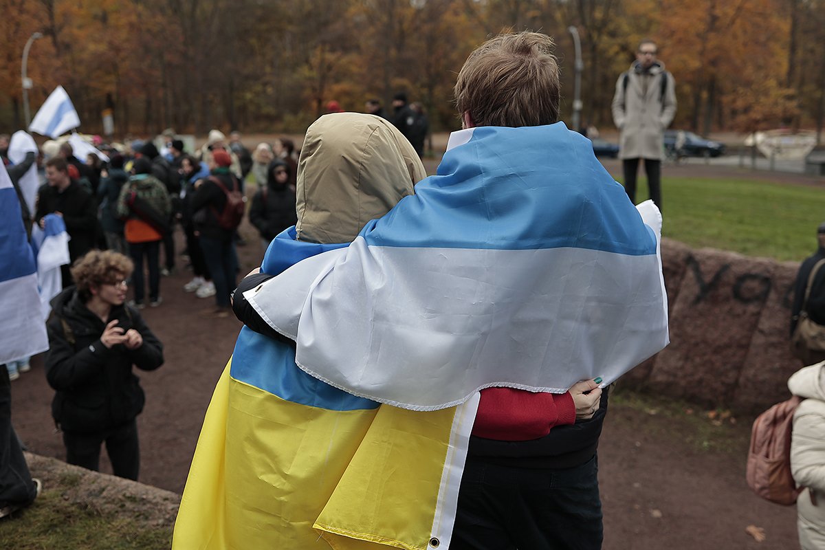 Участники митинга обернутые в флаг Украины и бело-сине-белый флаг. Фото: Василий Крестьянинов / «Новая газета Европа»